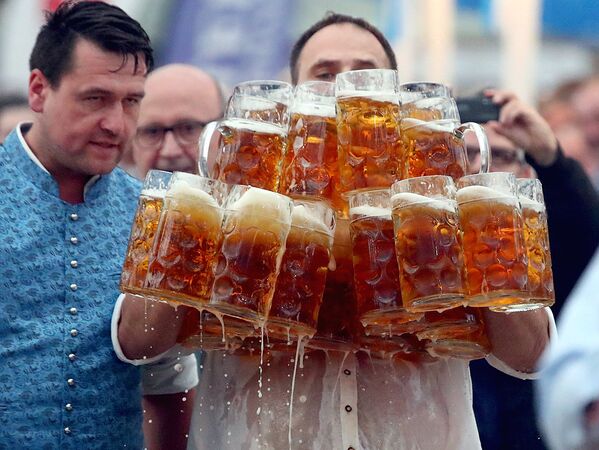 Попытка установить мировой рекорд в Абенсберге (Германия) по одновременному переносу максимального количества литровых кружек пива - Sputnik Узбекистан