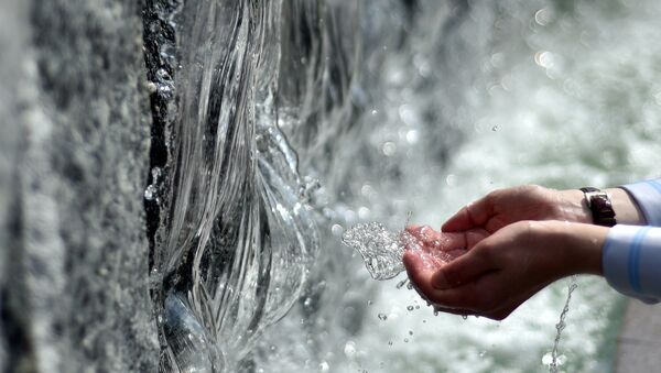 Человек набирает в ладони воду из фонтана - Sputnik Узбекистан