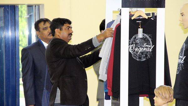 Посетители расматривают футболки на Международной хлопковой выставке в Ташкенте - Sputnik Ўзбекистон