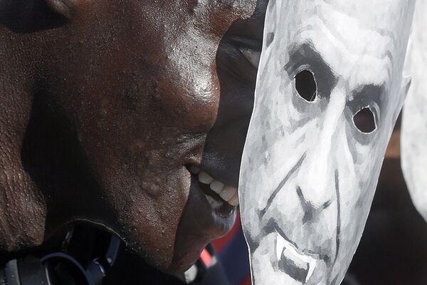 A demonstrator holds a mock mask depicting the Italian Interior Minister Marco Minniti as a Vampire during a pro-migrants and against racism demonstration, organized by a number of leftist organizations including labor unions, Amnesty International and MSF (Doctors Without Borders) in Rome, Saturday, Oct. 21, 2017 - Sputnik Узбекистан