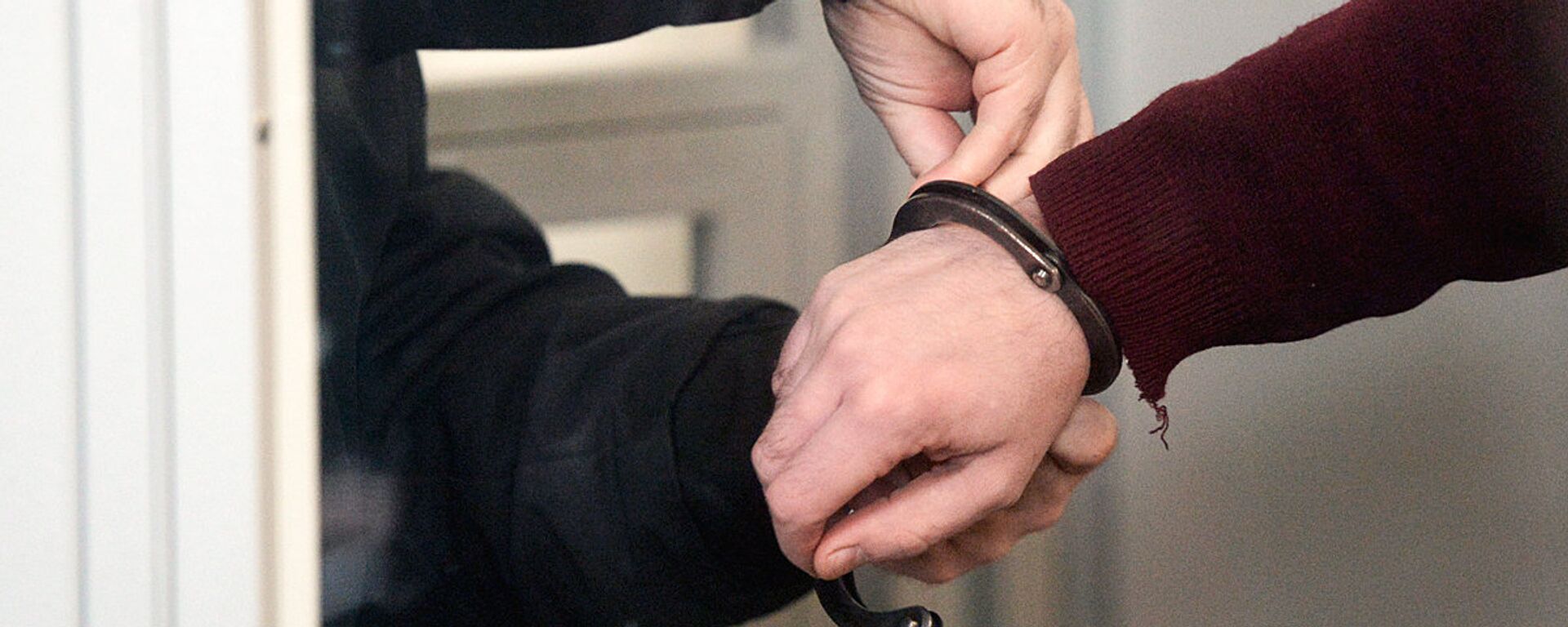 Сотрудник правоохранительных органов снимает наручники - Sputnik Узбекистан, 1920, 22.08.2020