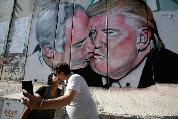 Туристы целуются у огромного граффити с Трампом и Нетаньяху - Sputnik Узбекистан