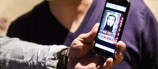 Мужчина смотрит на фотографию Сайфулло Саипова - Sputnik Узбекистан