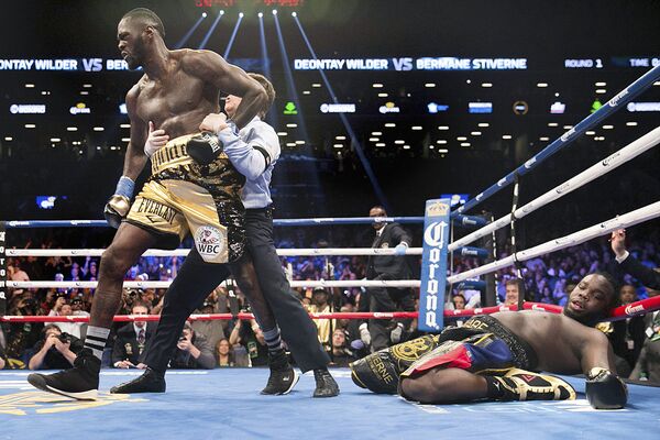 A referee pulls Deontay Wilder away from Bermane Stiverne after Wilder knocked out Stiverne during the WBC Heavyweight World Championship fight Saturday, Nov. 4, 2017, in New York. - Sputnik Узбекистан