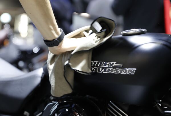 Мужчина протирает поверхность мотоцикла Harley Davidson на международной выставке мотоспорта EICMA MOTO в Милане - Sputnik Узбекистан