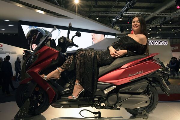 Модель позирует на новом Kymco Downtown 350i на международной выставке мотоспорта EICMA MOTO в Милане - Sputnik Узбекистан