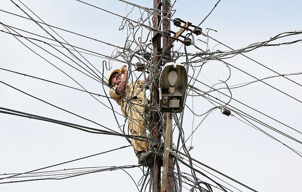 Работник ремонтирует линии электропередачи в городе Кочи, Индия - Sputnik Узбекистан