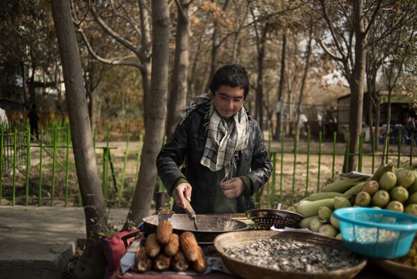 Юноша продает печеную кукурузу во дворе дома одного из районов Кабула - Sputnik Узбекистан