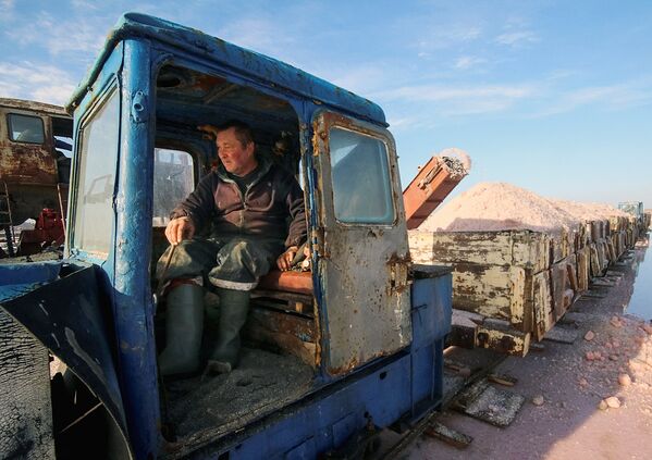 A train driver works at a salt production site at the Sasyk-Sivash lake near the city of Yevpatoria, Crimea - Sputnik Узбекистан