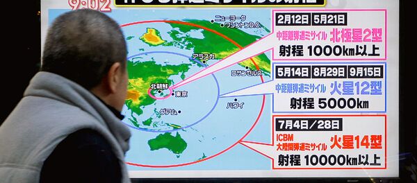 Мужчина в Токио смотрит новости о запуске ракеты с территории Северной Кореи - Sputnik Узбекистан
