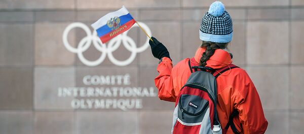 Девушка с российским флагом рядом со штаб-квартирой МОК в Лозанне - Sputnik Узбекистан