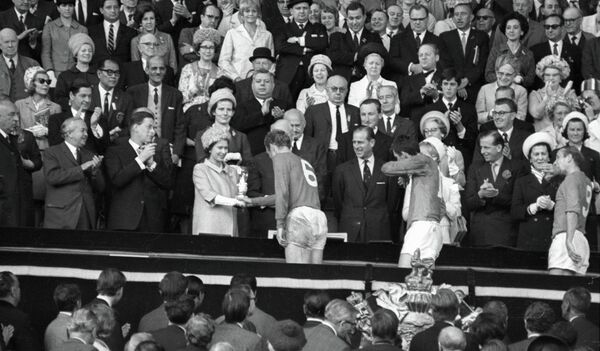 Королева Англии Елизавета II вручает приз VIII первенства мира по футболу Кубок Золотая богиня капитану английской сборной Роберту (Бобби) Муру - Sputnik Узбекистан