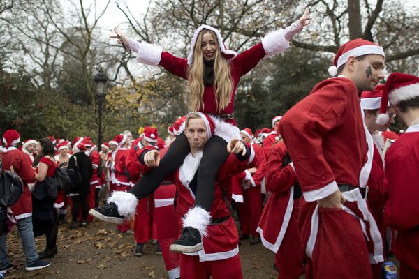 Лондонда Санта-Клаус костюмини кийиб олган кишилар, 2016 йил 10 декабрь. - Sputnik Ўзбекистон