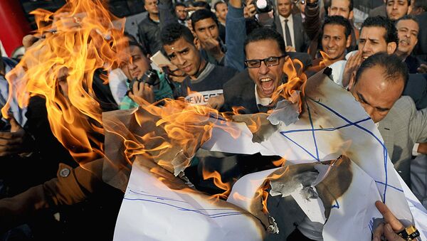 Протестующие кричат лозунги и сжигают израильский флаг во время антиизраильского протеста в Каире, Египет, 10 декабря 2017 года - Sputnik Ўзбекистон