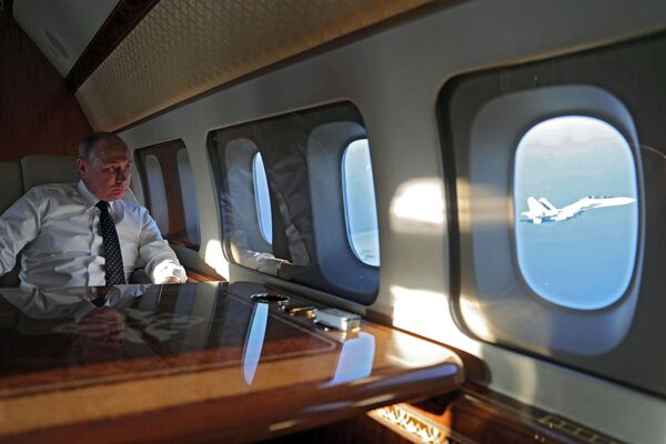 Президент РФ Владимир Путин на борту президентского самолета во время полета на авиабазу Хмеймим в Сирии - Sputnik Узбекистан