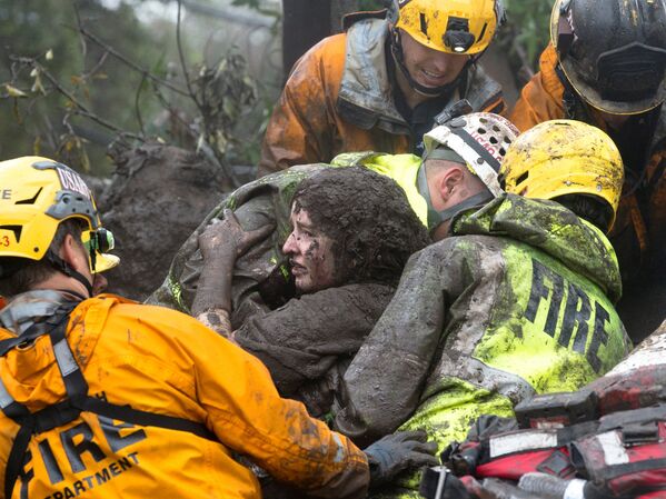 Спасатели достают женщину из под завалов ее дома, который был разрушен оползнем в Монтесито, Калифорния - Sputnik Узбекистан