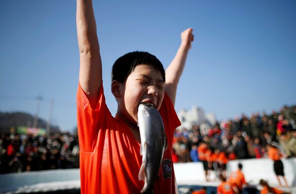 Мальчик, поймавший собственными руками форель, на празднике в поддержку грядущего Ледяного фестиваля в южнокорейском городе Хвачхон - Sputnik Узбекистан