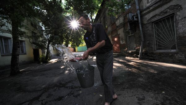 Иностранный рабочий выливает воду из ведра во дворе одного из домов - Sputnik Узбекистан