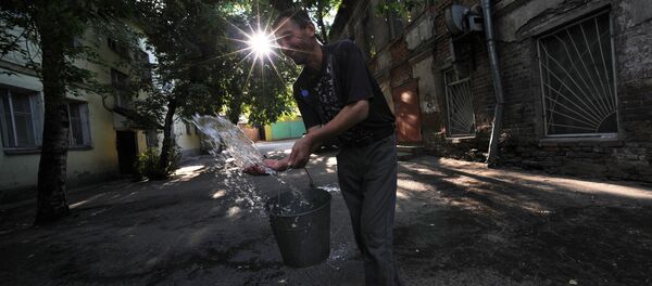 Иностранный рабочий выливает воду из ведра во дворе одного из домов - Sputnik Узбекистан