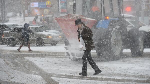Мужчина переходит дорогу во время снегопада - Sputnik Узбекистан