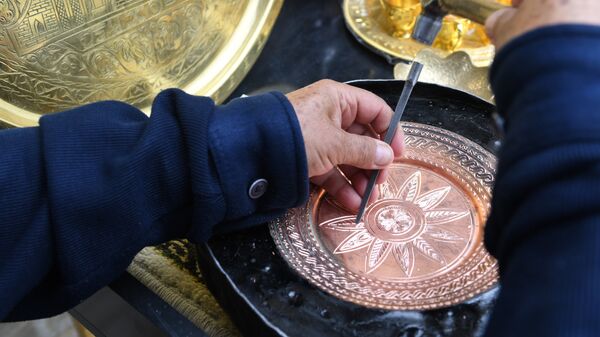 Чеканщик во время работы над изделием из металла для продажи туристам - Sputnik Узбекистан