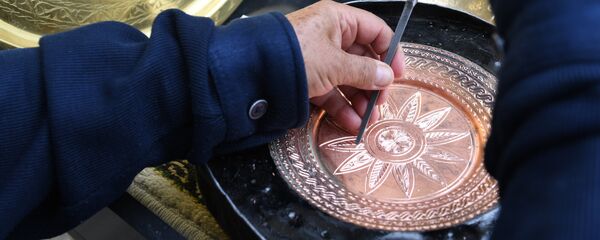 Чеканщик во время работы над изделием из металла для продажи туристам - Sputnik Узбекистан