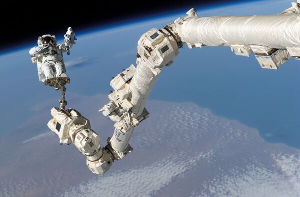 Астронавт Стивен Керн Робинсон в открытом космосе рядом с МКС - Sputnik Узбекистан