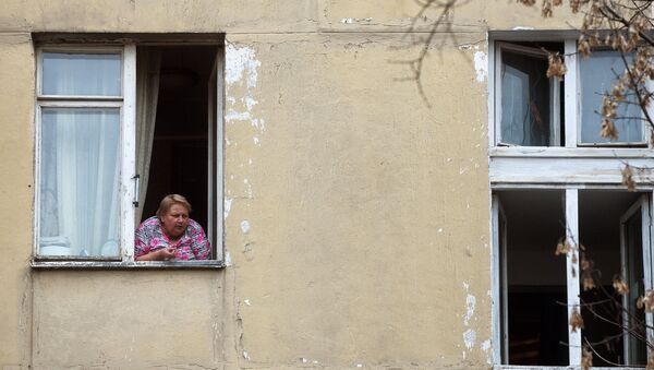 Женщина в окне пятиэтажного жилого дома  - Sputnik Узбекистан