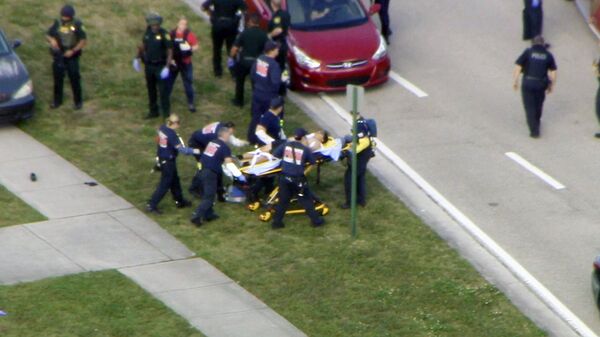 Эвакуация раненных из школы в Паркленде, где произошла стрельба Эвакуация раненных из школы в Паркленде, где произошла стрельба - Sputnik Узбекистан