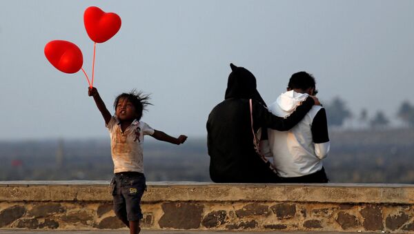 Ребенок с шариками-сердечками и пара на улице Мумбаи в День всех влюбленных, который отмечается 14 февраля по всему миру. - Sputnik Узбекистан