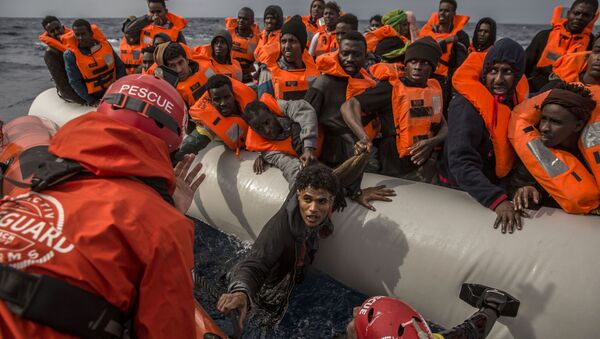 Спасение мигрантов сотрудниками испанской общественной организации Proactiva Open Arms с переполненной резиновой лодки у берегов Ливии - Sputnik Узбекистан