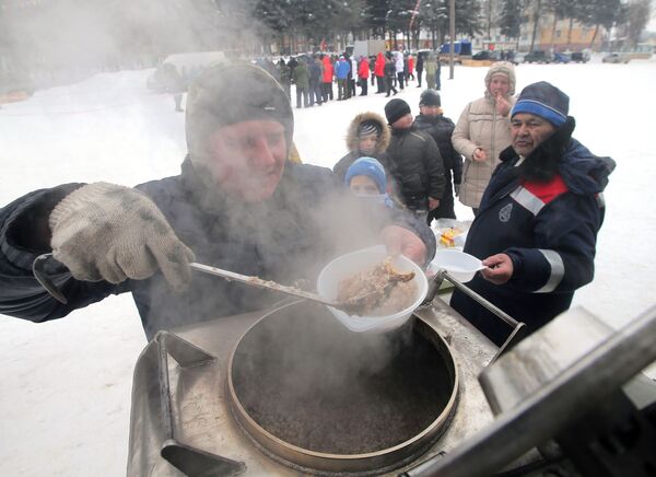 Мужчина накладывает еду в тарелки для посетителей седьмого всероссийского турнира Гусиные бои в посёлке Дубна Тульской области - Sputnik Узбекистан