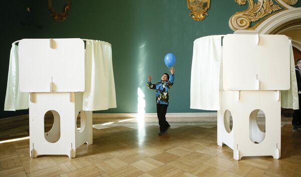 Ребенок с шариком на выборах президента РФ на избирательном участке на Казанском вокзале в Москве - Sputnik Узбекистан