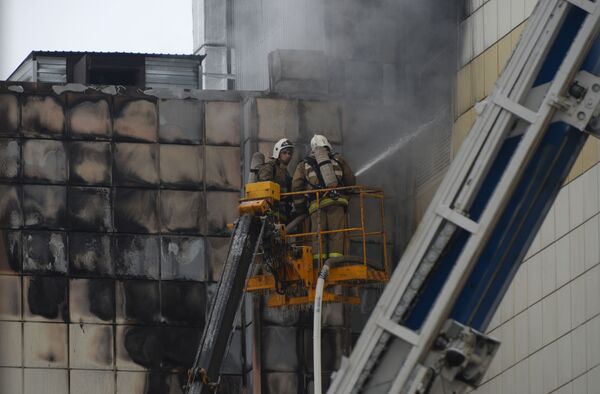 Сотрудники пожарной охраны МЧС во время тушения пожара в торговом центре Зимняя вишня в Кемерово - Sputnik Узбекистан