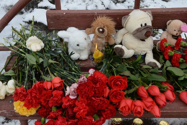 Цветы, свечи и мягкие игрушки возле здания торгового центра Зимняя вишня в Кемерово, где произошел пожар - Sputnik Узбекистан