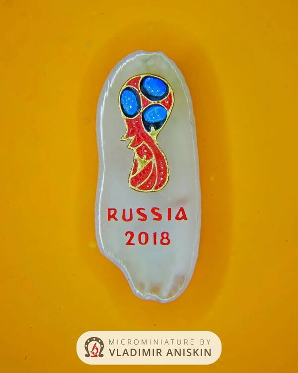 Эмблема чемпионата мира по футболу 2018 года на срезе рисового зернышка, сделанная микроминиатюристом Владимиром Анискиным / - Sputnik Узбекистан