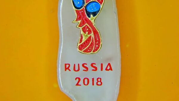 Эмблема чемпионата мира по футболу 2018 года на срезе рисового зернышка, сделанная микроминиатюристом Владимиром Анискиным / - Sputnik Узбекистан