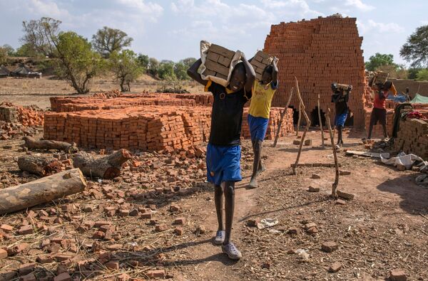В Южном Судане, где 60% населения моложе 18 лет, по данным ЮНИСЕФ - более 70%, в Ньямлеле в кирпичном бизнесе работают до 30 детей. Владелец кирпичного завода сказал, что он нанимает детей, потому что они дешевле, и он также полагает, что помогает семьям выжить.В Южном Судане, где 60% населения моложе 18 лет, по данным ЮНИСЕФ более 70%, в Ньямлеле в кирпичном бизнесе работают до 30 детей. Владелец кирпичного завода сказал, что он нанимает детей, потому что они дешевле, и он также полагает, что помогает семьям выжить. - Sputnik Узбекистан