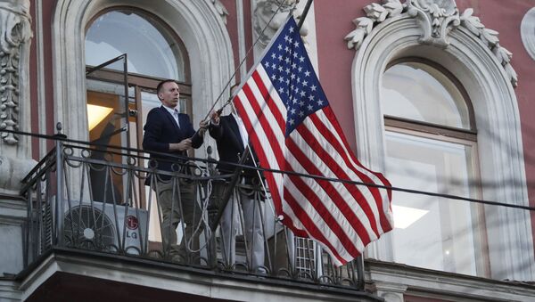 Сотрудники дипмиссии снимают государственный флаг США со здания американского генконсульства на Фурштатской улице в Санкт-Петербурге - Sputnik Узбекистан