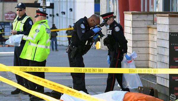 Офицер полиции делает снимок погибшего после того, как фургон протаранил нескольких человек в Торонто - Sputnik Ўзбекистон