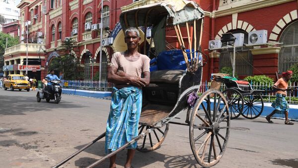 65-летний индийский рикша Мохаммад Ашгар рядом со своей повозкой в Колкате - Sputnik Узбекистан