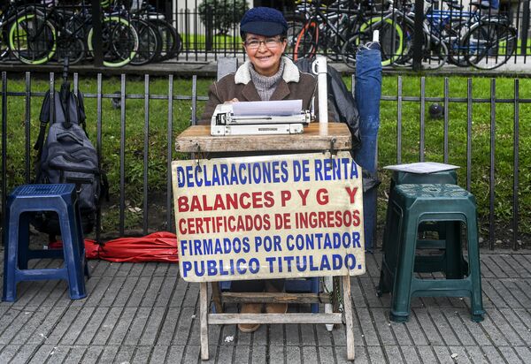 Уличный клерк Канделария Пинилла 63 лет за своим столом перед районным налоговым управлением в Боготе, Колумбия - Sputnik Узбекистан