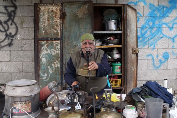 Мастер по ремонту керосиновых плит Jawdat al-Khour за его лавкой в Газе - Sputnik Узбекистан