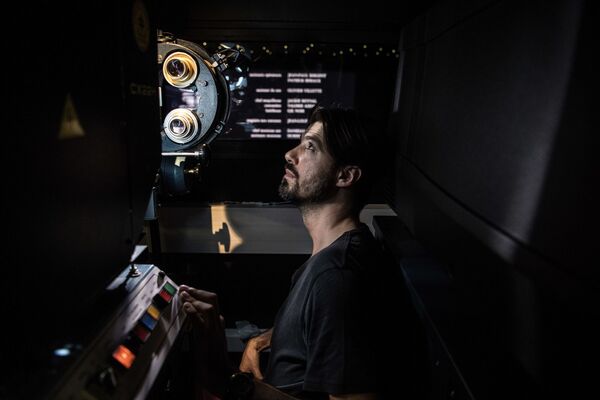 Киномеханик Benjamin Louis проверяет проекцию пленочного фильма в кинотеатре Louxor в Париже, Франция - Sputnik Узбекистан