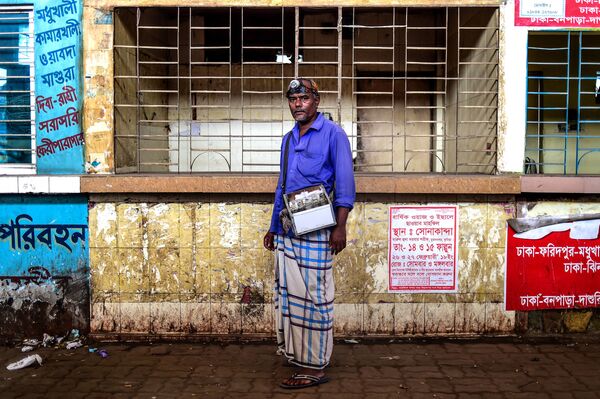 Чистильщик ушей Mohammad Joynal на улице, где он работает, в Дакке, Бангладеш - Sputnik Узбекистан