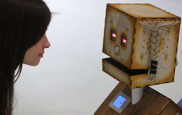 Посетительница рассматривает робота Деревяку компании Robodem на форуме-выставке Skolkovo Robotics в Москве - Sputnik Узбекистан
