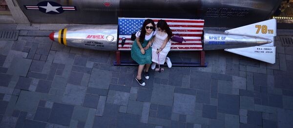 Девушки фотографируются на скамейке-ракете внутри пекинского магазина - Sputnik Узбекистан