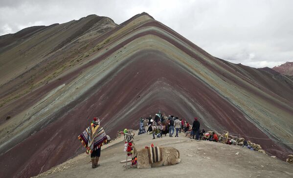 Коренной житель Анд с ламой и туристы напротив горы Виникунка в Перу - Sputnik Узбекистан