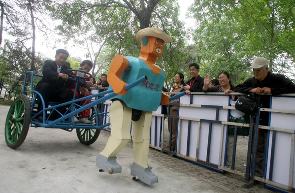 Китайский крестьянин в повозке, запряженной собранным им роботом, в парке Пекина - Sputnik Узбекистан