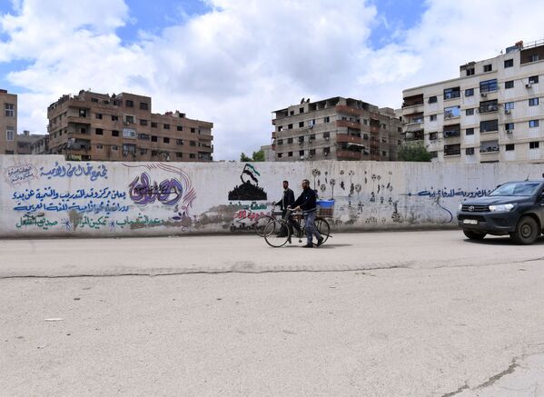 Мужчины с велосипедом в районе бывшего лагеря палестинских беженцев Ярмук в южном пригороде Дамаска. - Sputnik Узбекистан